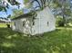 Exterior view of a detached white garage with a side door and windows, set in a grassy yard at 1739 E 18Th St, Anderson, IN 46016