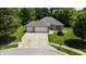 An aerial shot of a well-kept home boasts a green lawn, mature trees, a wide driveway, and a two-car garage, enhancing its appeal at 1819 Quiet Haven Cir, Indianapolis, IN 46229