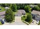 Aerial view of a home featuring a well-manicured lawn, mature trees, and a large driveway, adding to the property's curb appeal at 1819 Quiet Haven Cir, Indianapolis, IN 46229