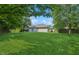 Expansive backyard showcasing a lush, green lawn and a view of the home's exterior at 1819 Quiet Haven Cir, Indianapolis, IN 46229
