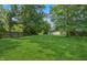 A wide shot of the backyard with mature trees and a well-kept lawn, perfect for outdoor enjoyment at 1819 Quiet Haven Cir, Indianapolis, IN 46229