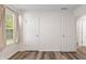 Bedroom with wood-look floors, neutral walls, a window with privacy blinds and three doors at 1819 Quiet Haven Cir, Indianapolis, IN 46229
