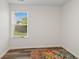 Cozy bedroom featuring wood-look floors, a colorful rug and a sunlit window overlooking the backyard at 1819 Quiet Haven Cir, Indianapolis, IN 46229