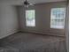 Bedroom with neutral carpet, ceiling fan, and two windows at 18851 Wimbley Way, Noblesville, IN 46060