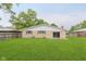 Expansive backyard featuring a well-maintained lawn, mature trees, and a sliding glass door to the home at 2925 E 8Th St, Anderson, IN 46012