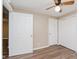 Neutral bedroom featuring wood-look flooring, ceiling fan, and white doors at 2925 E 8Th St, Anderson, IN 46012