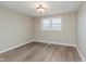 Bright bedroom featuring wood-look flooring, neutral paint, and a window providing natural light at 2925 E 8Th St, Anderson, IN 46012