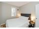 Comfortable bedroom with a padded headboard, side tables, and natural light from the window at 3011 N New Jersey St, Indianapolis, IN 46205