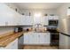 Well-lit kitchen with white cabinets, butcher block countertops, and stainless steel appliances, creating a functional space at 3011 N New Jersey St, Indianapolis, IN 46205