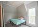 Cozy bedroom featuring carpet, one twin bed, an angled ceiling and a bright window at 307 E 5Th St, Sheridan, IN 46069