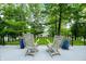A cozy backyard deck with wicker chairs and blue flower pots facing the grassy yard and lake at 3695 Windsor Pl, Martinsville, IN 46151