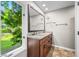 Bathroom features a granite countertop, double sinks, wood cabinets, and a large mirror overlooking a nature view at 3695 Windsor Pl, Martinsville, IN 46151