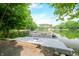 View of a private boat dock with a pontoon boat on a serene lake surrounded by lush greenery at 3695 Windsor Pl, Martinsville, IN 46151