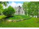 Beautifully landscaped home exterior featuring a stone facade, a green lawn, and mature trees at 3695 Windsor Pl, Martinsville, IN 46151