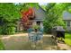 Cozy exterior patio with a blue metal table set and a grill, surrounded by lush greenery and a house at 3695 Windsor Pl, Martinsville, IN 46151