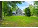 Lush, landscaped yard showcasing stone house with expansive windows and an outdoor deck at 3695 Windsor Pl, Martinsville, IN 46151