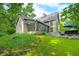 Expansive home exterior featuring a stone facade, a wall of windows, and a manicured lawn at 3695 Windsor Pl, Martinsville, IN 46151