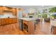Open concept kitchen with stone fireplace, stainless steel refrigerator, island and backyard views at 3695 Windsor Pl, Martinsville, IN 46151