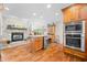 Bright kitchen boasts stone fireplace, wood floors, stainless appliances and center island with wine cooler at 3695 Windsor Pl, Martinsville, IN 46151