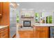 Open kitchen showcases stone fireplace, stainless steel refrigerator and center island with wine cooler at 3695 Windsor Pl, Martinsville, IN 46151