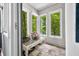 Bright sun room with a wicker table and large windows offering lovely views of the lush trees outside at 3695 Windsor Pl, Martinsville, IN 46151