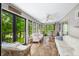Bright sunroom with white wicker furniture, tile flooring, and views of the surrounding greenery at 3695 Windsor Pl, Martinsville, IN 46151