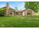 Spacious backyard with lush green grass and a brick patio at 3714 Timberview Ct, Anderson, IN 46011