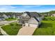 Aerial view of a gray and stone accented two-story home with a well-manicured lawn and a three-car garage at 4416 Eaglecrest Pl, Zionsville, IN 46077