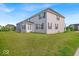 Spacious backyard featuring lush green lawn and the home's exterior with classic siding and dark shutters at 4416 Eaglecrest Pl, Zionsville, IN 46077