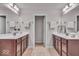 Bathroom featuring double sinks, tile floors, and decorative mirrors with modern lighting at 4416 Eaglecrest Pl, Zionsville, IN 46077