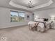 Sun-filled primary bedroom with carpet floors, tray ceilings, and ample natural light at 4416 Eaglecrest Pl, Zionsville, IN 46077