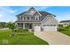 Inviting two-story home boasts a stone facade, a two-car garage, and a beautifully landscaped front yard at 4416 Eaglecrest Pl, Zionsville, IN 46077