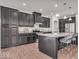 Stylish kitchen featuring stainless steel appliances, dark cabinets, a granite countertop, and counter seating at 4416 Eaglecrest Pl, Zionsville, IN 46077