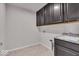 Functional laundry room featuring overhead cabinets, sink, and tile floor at 4416 Eaglecrest Pl, Zionsville, IN 46077