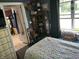 Bedroom showing a floral patterned bedspread, natural light, and an interior view of a utility room at 5091 Alexandria Pike, Anderson, IN 46012