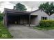 View of a single-story home exterior with a convenient carport, green shutters, and neatly kept landscaping at 5091 Alexandria Pike, Anderson, IN 46012
