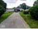 Property exterior featuring a long driveway leading to a one-story home and a detached garage at 5091 Alexandria Pike, Anderson, IN 46012
