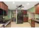 Efficient kitchen with dark cabinets, stainless steel appliances, and a view into the hallway, optimizing space and functionality at 5110 S State Ave, Indianapolis, IN 46227