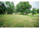 Vast backyard with lush green grass, mature trees, and various outbuildings that enhance outdoor living at 5116 W County Road 450 S, Coatesville, IN 46121