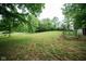 Lush backyard featuring a well-manicured lawn, mature trees and a white fence along the perimeter at 5116 W County Road 450 S, Coatesville, IN 46121