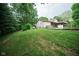 Backyard view with a hot tub, a propane tank, and house featuring a covered carport at 5116 W County Road 450 S, Coatesville, IN 46121