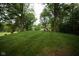 Expansive backyard with mature trees surrounding the manicured lawn, great for outdoor activities and privacy at 5116 W County Road 450 S, Coatesville, IN 46121