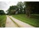 Gravel driveway leading to the property, surrounded by green lawn and trees at 5116 W County Road 450 S, Coatesville, IN 46121