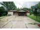 Exterior view of a single-story home with a covered carport and basketball hoop on a cracked driveway at 5116 W County Road 450 S, Coatesville, IN 46121