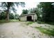 Spacious two-car detached garage with an open door and an adjacent gravel driveway and trees at 5116 W County Road 450 S, Coatesville, IN 46121