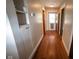 Hallway features natural wood floors with built-in shelving for storage and a paneled front door at 5116 W County Road 450 S, Coatesville, IN 46121