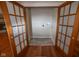 A laundry room features stylish tile floor, wooden trim, and a set of frosted french doors at 5116 W County Road 450 S, Coatesville, IN 46121