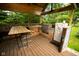 Outdoor kitchen with a bar, built in kitchen cabinets, stone grill, and wood deck at 5116 W County Road 450 S, Coatesville, IN 46121