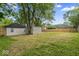A large backyard includes a storage shed and fencing, surrounded by mature trees, ideal for privacy at 5136 Miller St, Indianapolis, IN 46241