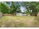 A sprawling backyard enclosed by a wooden fence is enhanced by mature trees, creating privacy at 5136 Miller St, Indianapolis, IN 46241